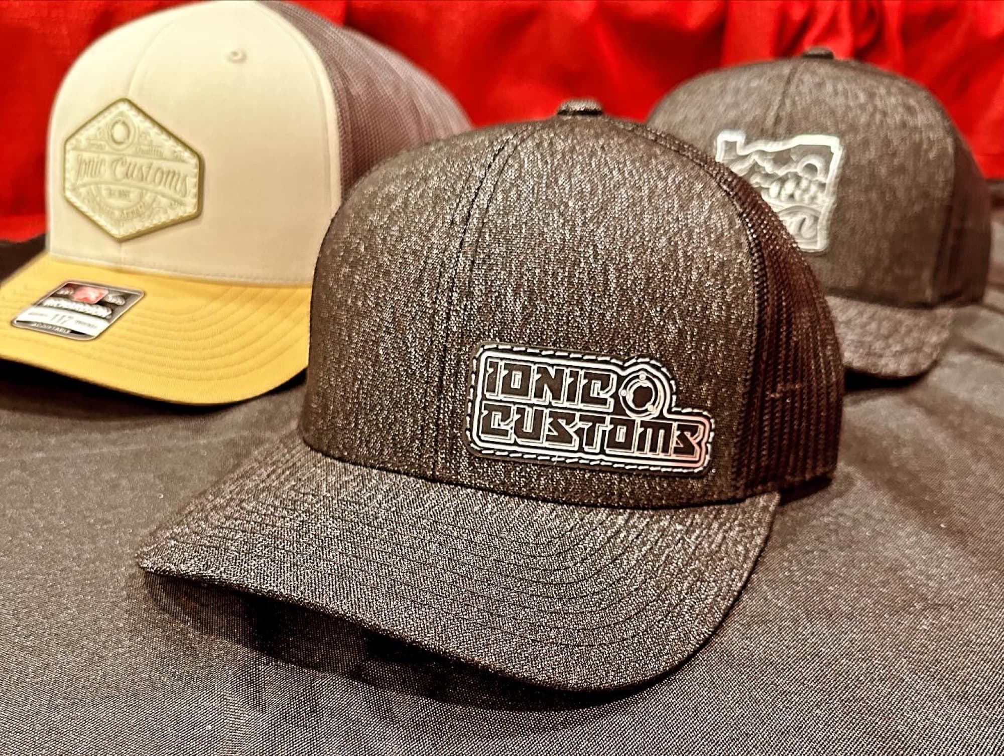 Three Ionic Customs trucker hats with engraved leather patches