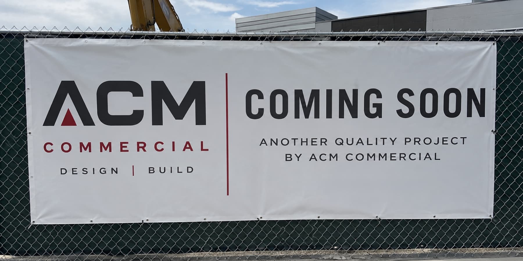 Installed grommeted vinyl banner on a construction site fence
